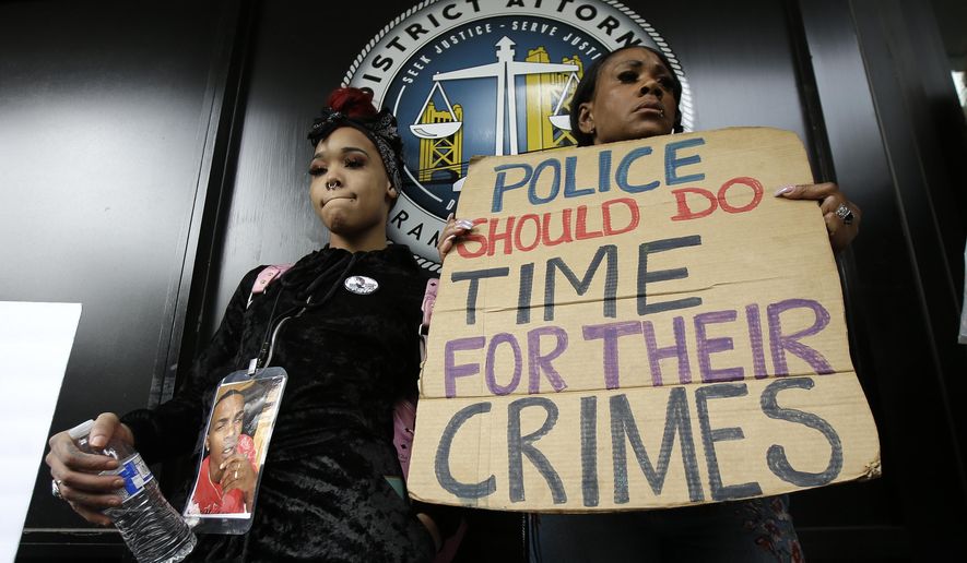 FILE - This April 4, 2018, file photo shows protesters standing outside the office of Sacramento County District Attorney Anne Marie Schubert calling for the indictment of two Sacramento police officers in the shooting death of Stephon Clark, 22, during a rally in Sacramento, Calif. Officials say Thursday, Sept. 26, 2019, a federal review of the 2018 shooting of Clark found "insufficient evidence" to pursue charges against Sacramento Police Officers Terrance Mercadal and Jared Robinet. (AP Photo/Rich Pedroncelli, File)
