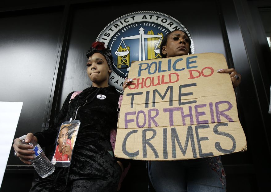FILE - This April 4, 2018, file photo shows protesters standing outside the office of Sacramento County District Attorney Anne Marie Schubert calling for the indictment of two Sacramento police officers in the shooting death of Stephon Clark, 22, during a rally in Sacramento, Calif. Officials say Thursday, Sept. 26, 2019, a federal review of the 2018 shooting of Clark found "insufficient evidence" to pursue charges against Sacramento Police Officers Terrance Mercadal and Jared Robinet. (AP Photo/Rich Pedroncelli, File)
