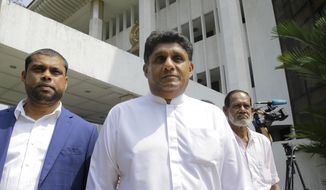 FILE- In this Nov. 12, 2018 file photo, Sri Lankan lawmaker Sajith Premadasa, center, leaves the supreme courts complex after attending a filing in of a petition in Colombo, Sri Lanka. Sri Lanka&#39;s governing coalition has named its charismatic deputy leader, Premadasa, as its candidate for in November&#39;s presidential election, ending a long tussle with the party leader, Prime Minister Ranil Wickremesinghe, over the nomination. (AP Photo/Eranga Jayawardena, File)