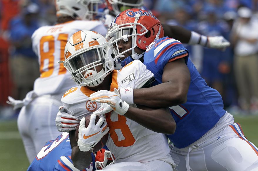 Tennessee running back Ty Chandler, left, is stopped by Florida linebacker James Houston IV after a short gain during the second half of an NCAA college football game, Saturday, Sept. 21, 2019, in Gainesville, Fla. (AP Photo/John Raoux)