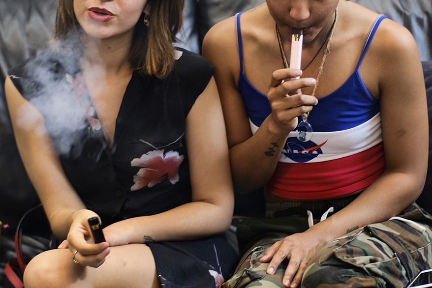 In this Saturday, June 8, 2019, file photo, two women smoke cannabis vape pens at a party in Los Angeles. (AP Photo/Richard Vogel) ** FILE **