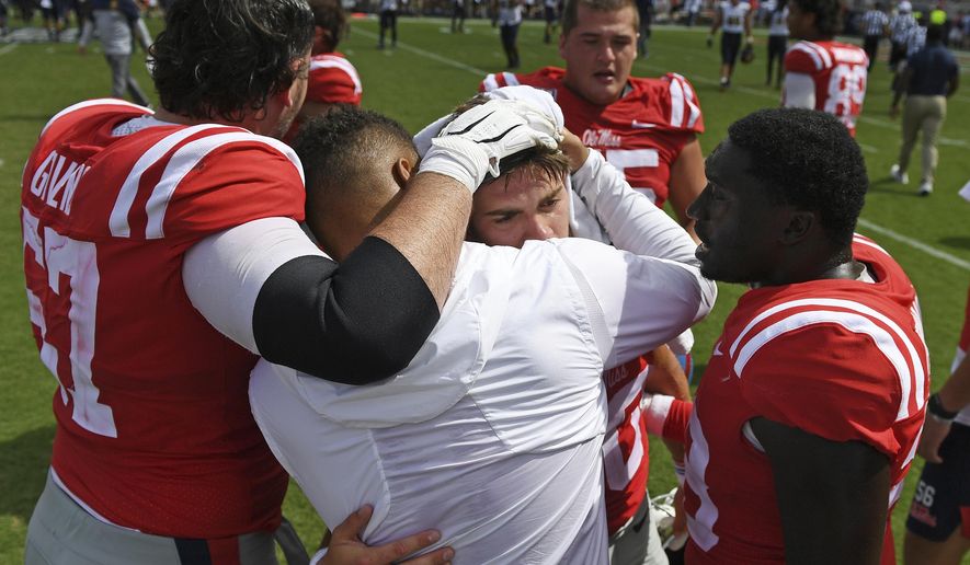 Mississippi players console quarterback John Rhys Plumlee, center, after an NCAA college football game against California in Oxford, Miss., Saturday, Sept. 21, 2019. California won 28-20. (AP Photo/Thomas Graning)
