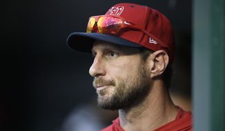 Washington Nationals&#39; Max Scherzer stands in the dugout during a baseball game against the Cleveland Indians, Saturday, Sept. 28, 2019, in Washington. The Nationals won 10-7. (AP Photo/Nick Wass)