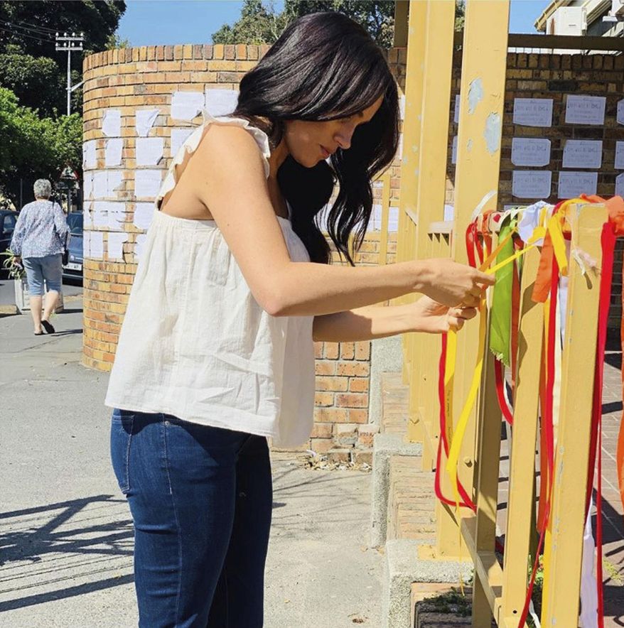In this undated handout photo taken from the Sussex Royal instagram account, Britain's Meghan, the Duchess of Sussex visits the memorial to a murdered South African student as a "personal gesture" after "closely following the tragic story". In a quiet visit, Meghan tied a ribbon to the memorial at the post office where university student Uyinene Mrwetyana was attacked. A post on the royals' Instagram account calls the death "a critical point in the future of women's rights in South Africa," where more than 100 rapes are reported every day. (Sussex Royal via AP)