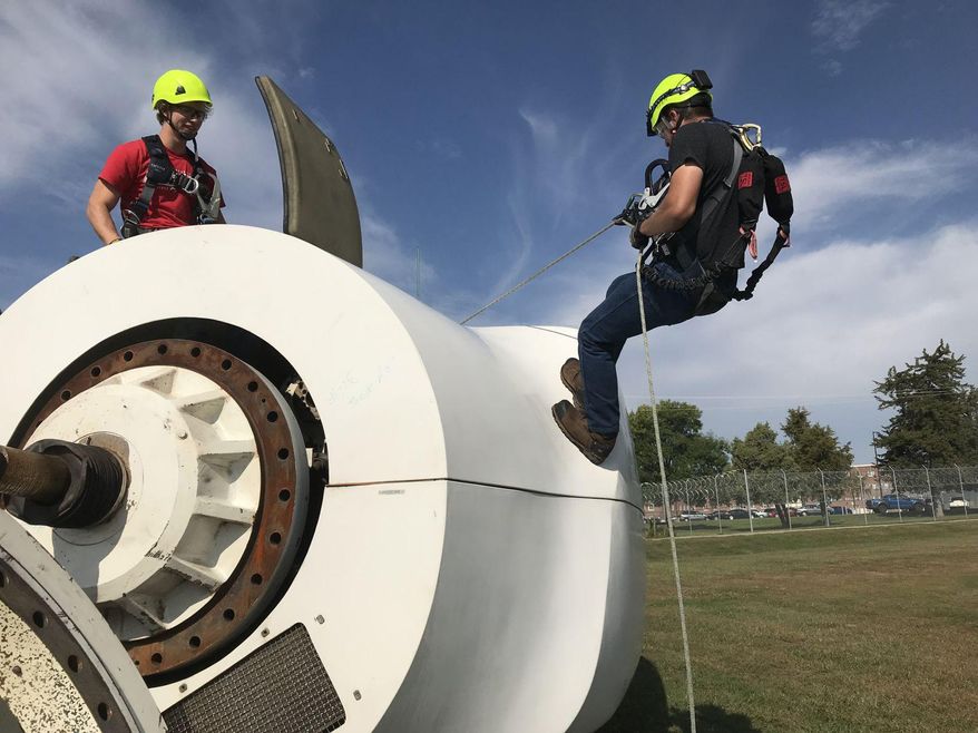 Northeast Community College students practice rappelling from a wind turbine nacelle donated by NextEra Energy in Lincoln, Neb. Wind Energy Fundamentals teaches the aspiring technicians climbing techniques and safety procedures. (Lincoln Journal Star via AP)