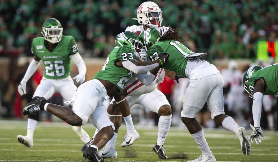 North Texas linebacker KD Davis (23) and defensive back Deshawn Gaddie (17) attempt to take down Houston wide receiver Bryson Smith (1) during the first half of an NCAA college football game on Saturday, Sept. 28, 2019, in Denton, Texas. (Kara Dry/The Denton Record-Chronicle via AP)