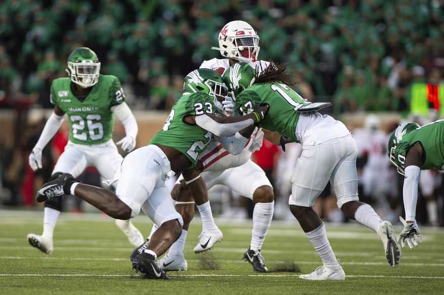 North Texas linebacker KD Davis (23) and defensive back Deshawn Gaddie (17) attempt to take down Houston wide receiver Bryson Smith (1) during the first half of an NCAA college football game on Saturday, Sept. 28, 2019, in Denton, Texas. (Kara Dry/The Denton Record-Chronicle via AP)