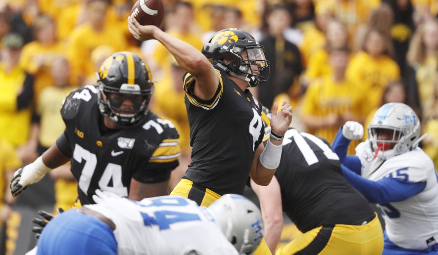 Iowa quarterback Nate Stanley, center, throws a pass during the first half of an NCAA college football game against Middle Tennessee, Saturday, Sept. 28, 2019, in Iowa City, Iowa. (AP Photo/Charlie Neibergall)