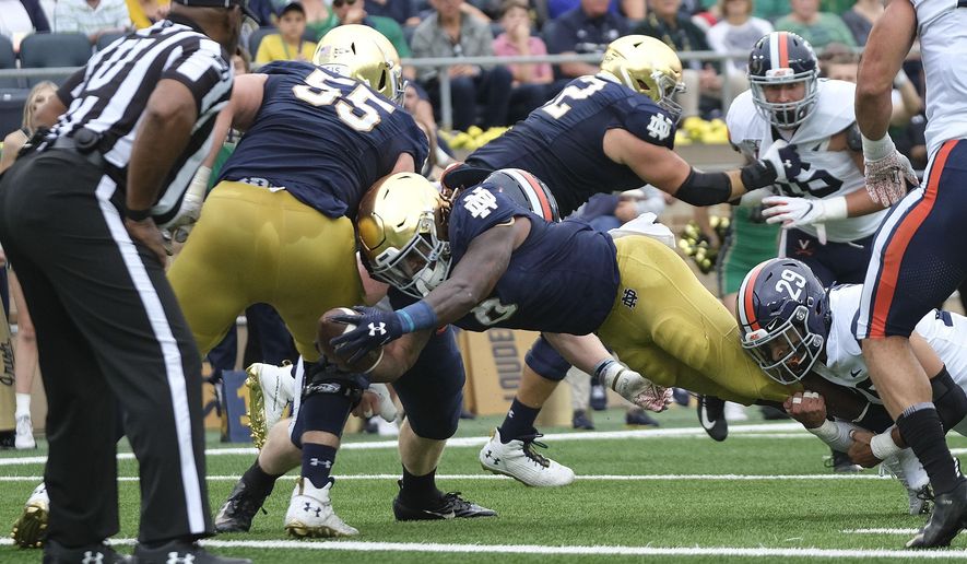 Notre Dame running back Tony Jones Jr. (6) scores while being tackled by Virginia safety Joey Blount (29) in the first half of an NCAA college football game in South Bend, Ind., Saturday, Sept. 28, 2019. (AP Photo/AJ Mast)