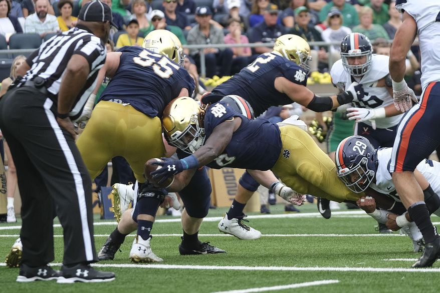 Notre Dame running back Tony Jones Jr. (6) scores while being tackled by Virginia safety Joey Blount (29) in the first half of an NCAA college football game in South Bend, Ind., Saturday, Sept. 28, 2019. (AP Photo/AJ Mast)