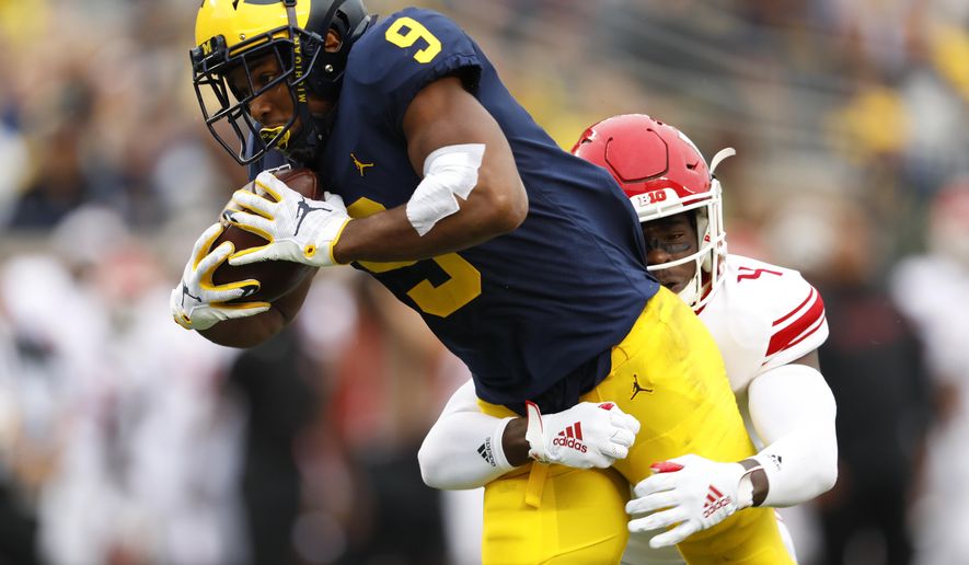 Michigan wide receiver Donovan Peoples-Jones (9) tries to break the tackle of Rutgers defensive back Tre Avery (4) in the first half of an NCAA college football game in Ann Arbor, Mich., Saturday, Sept. 28, 2019. (AP Photo/Paul Sancya)