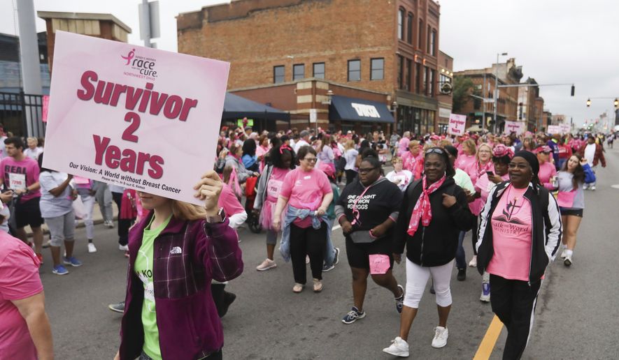 Breast cancer survivors walk to the start of the 26th Annual Susan G. Komen Northwest Ohio Race for the Cure in the Survivors Parade on Monroe Street in downtown Toledo, Ohio, on Sunday, Sept. 29, 2019. (Rebecca Benson/The Blade via AP) ** FILE **