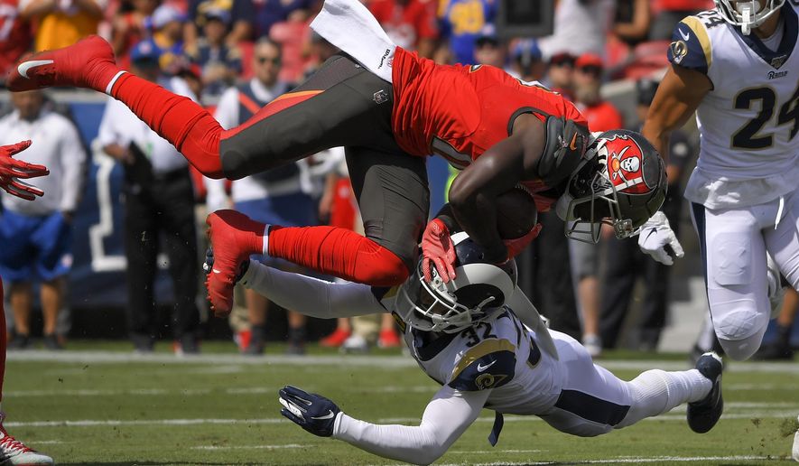 Tampa Bay Buccaneers wide receiver Chris Godwin, top, is tackled by Los Angeles Rams free safety Eric Weddle during the first of an NFL football game Sunday, Sept. 29, 2019, in Los Angeles. (AP Photo/Mark J. Terrill)