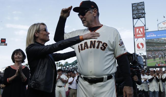 San Francisco Giants manager Bruce Bochy, right, hugs his wife Kim during a ceremony honoring Bochy after a baseball game between the Giants and the Los Angeles Dodgers in San Francisco, Sunday, Sept. 29, 2019. (AP Photo/Jeff Chiu, Pool)