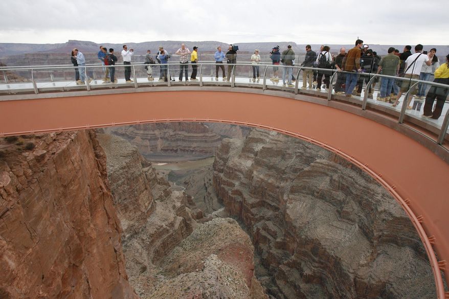 FILE - In this March 20, 2007, file photo, people walk on the Skywalk during the first walk event at the Grand Canyon on the Hualapai Indian Reservation at Grand Canyon West, Ariz. Authorities are trying to locate the body of a man who climbed over a safety barrier at the Grand Canyon Skywalk and apparently jumped to his death. (AP Photo/Ross D. Franklin, File)