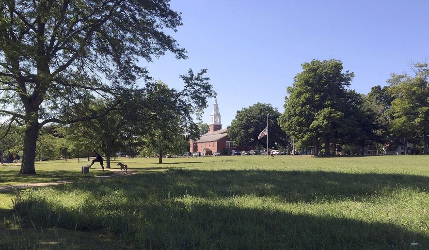 FILE - In this July 20, 2016 file photo, children and joggers enjoy the town green outside the First Congregational Church in Lebanon, Conn. A September 2019 ruling by a Superior Court judge has given the town ownership of its mile-long green. The ruling ends a dispute over ownership dating to 1705 document that showed the green belonged to the "heirs and assigns" of 51 original proprietors, the 17th and early 18th-century investors in the property. (AP Photo/Pat Eaton-Robb, File)