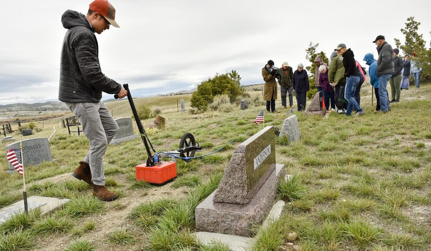 Ethan Ryan, archaeologist and PhD candidate at the University of Montana, illustrates the use of a ground-penetrating radar on Thursday, Sept. 26, 2019  while conference attendants watch the monitor for sub-surface objects at the Silver City Cemetery outside Silver City, Mont.  (Thom Bridge/Independent Record via AP)