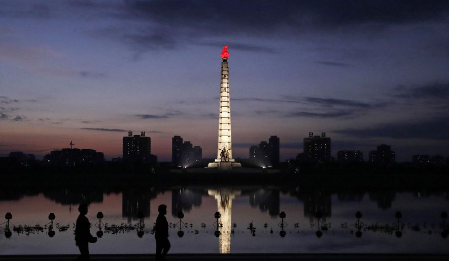 In this Sept. 15, 2018, photo, North Koreans take a walk at dawn by the Tower of Juche Idea in Pyongyang, North Korea. The word Juche is splashed across countless propaganda signs in North Korea and featured in hundreds of state media reports, and while it’s technically a political ideology, it can seem more like a religion because of its difficulty for many outsiders to grasp and ability to inspire devotion among North Koreans. (AP Photo/Kin Cheung)