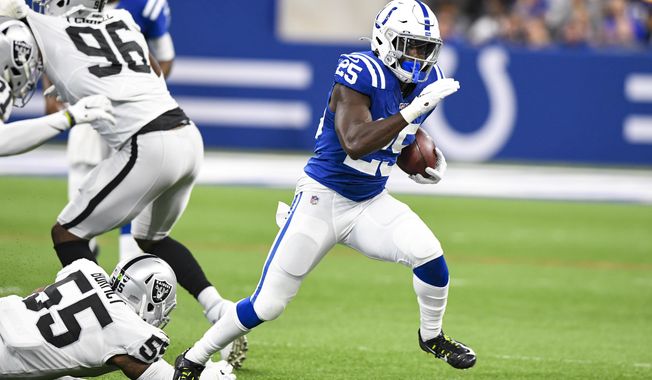 Indianapolis Colts running back Marlon Mack (25) breaks way from Oakland Raiders outside linebacker Vontaze Burfict (55) during the first half of an NFL football game in Indianapolis, Sunday, Sept. 29, 2019. (AP Photo/Doug McSchooler)