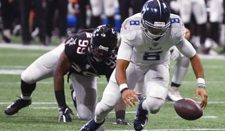 Tennessee Titans quarterback Marcus Mariota (8) works to recover his fumble against the Atlanta Falcons during the second half of an NFL football game, Sunday, Sept. 29, 2019, in Atlanta. (AP Photo/John Amis)