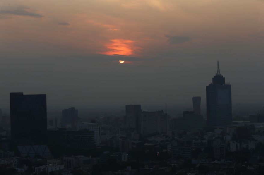 FILE - In this May 17, 2019 file photo, Smog blankets the sky in Mexico City. Both lower schools and universities were closed for a third straight day for the pollution alert triggered by smoke from ongoing brush fires combined with the lack of rain. (AP Photo/Marco Ugarte, File)