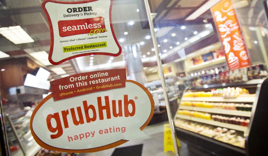 FILE - This April 4, 2014 file photo shows signage for food delivery services GrubHub and Seamless displayed on the door of a restaurant in New York. The growing options for outsourcing meal planning, grocery shopping and cooking can be called time-saving blessings or culture-destroying curses. In the end, they're probably a complicated mix of both. (AP Photo/Mark Lennihan, File)