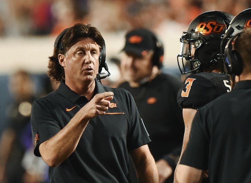 Oklahoma State head coach Mike Gundy points to his staff on the sidelines during the first half of an NCAA college football game against Kansas State, in Stillwater, Okla., Saturday, Sept. 28, 2019. (AP Photo/Brody Schmidt)