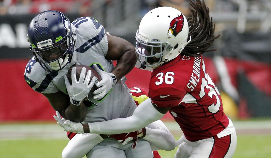Arizona Cardinals free safety D.J. Swearinger (36) tackles Seattle Seahawks wide receiver Jaron Brown (18) during the first half of an NFL football game, Sunday, Sept. 29, 2019, in Glendale, Ariz. (AP Photo/Rick Scuteri)