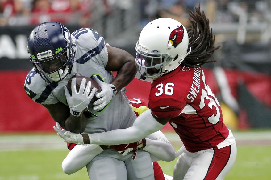 Arizona Cardinals free safety D.J. Swearinger (36) tackles Seattle Seahawks wide receiver Jaron Brown (18) during the first half of an NFL football game, Sunday, Sept. 29, 2019, in Glendale, Ariz. (AP Photo/Rick Scuteri)