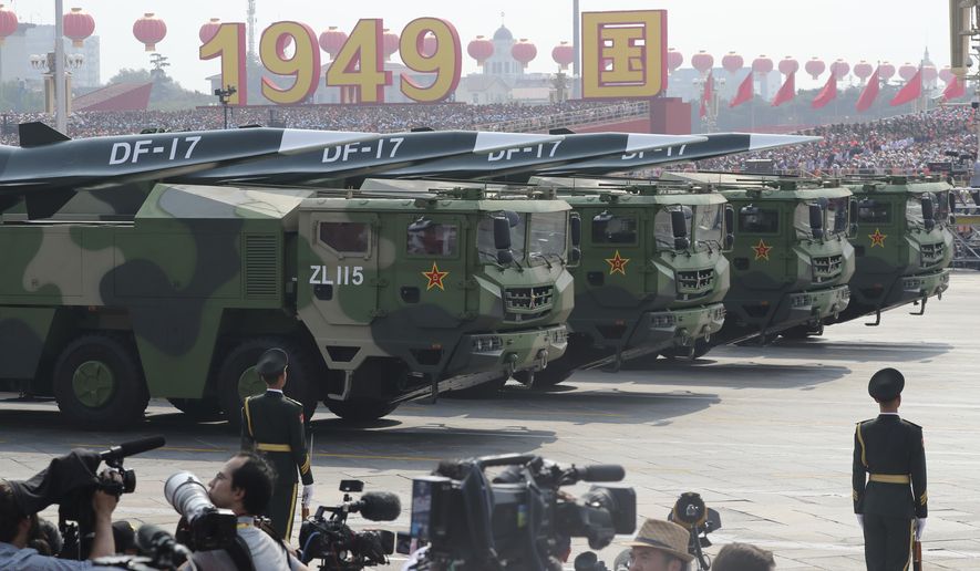 Military vehicles, carrying DF-17, roll down as members of a Chinese military honor guard march during the parade to commemorate the 70th anniversary of the founding of Communist China in Beijing, Tuesday, Oct. 1, 2019.  China&#39;s military has shown off a new hypersonic ballistic nuclear missile believed capable of breaching all existing anti-missile shields deployed by the U.S. and its allies. The vehicle-mounted DF-17 was among weapons displayed Tuesday in a massive military parade marking the 70th anniversary of the founding of the Chinese state.(AP Photo/Ng Han Guan)