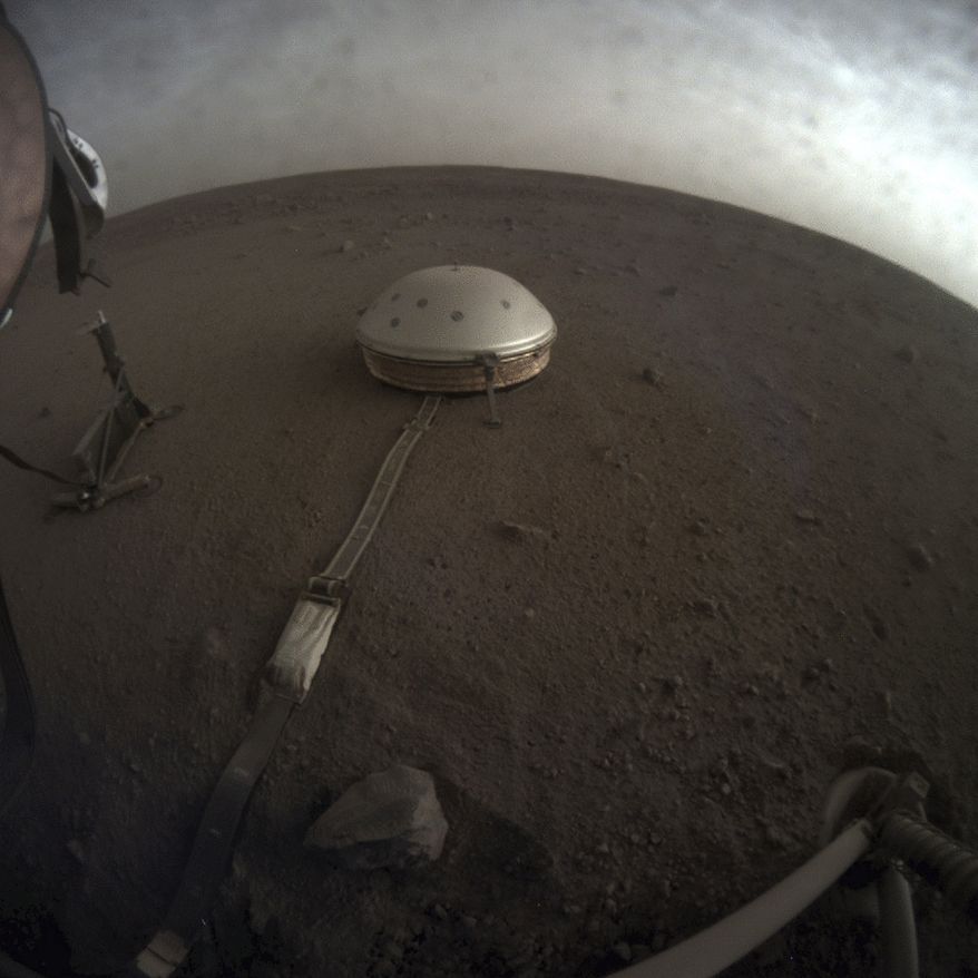 This April 25, 2019, file photo made available by NASA shows the InSight lander's dome-covered seismometer, known as SEIS, on Mars. On Tuesday, Oct. 1, 2019, scientists released an audio sampling of marsquakes and other sounds recorded by the probe. (NASA/JPL-Caltech via AP)
