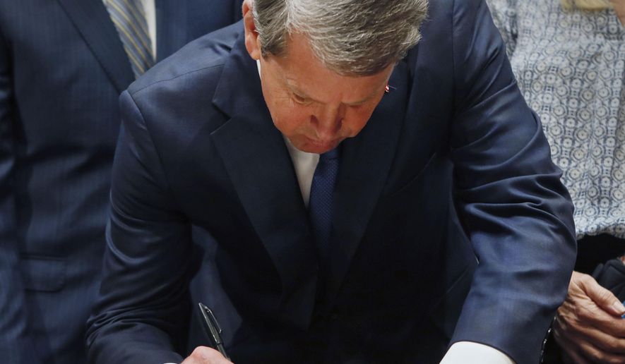File-This May 7, 2019, file photo shows Georgia's Republican Gov. Brian Kemp signing legislation, in Atlanta, banning abortions once a fetal heartbeat can be detected. A federal judge on Tuesday, Oct. 1, 2019, temporarily blocked Georgia’s restrictive new abortion law from taking effect, following the lead of other judges who have blocked similar measures in other states. The law signed in May by Republican Gov. Brian Kemp bans abortions once a fetal heartbeat is detected, which can happen as early as six weeks into a pregnancy, before many women realize they’re expecting. It allows for limited exceptions. (Bob Andres/Atlanta Journal-Constitution via AP, File)