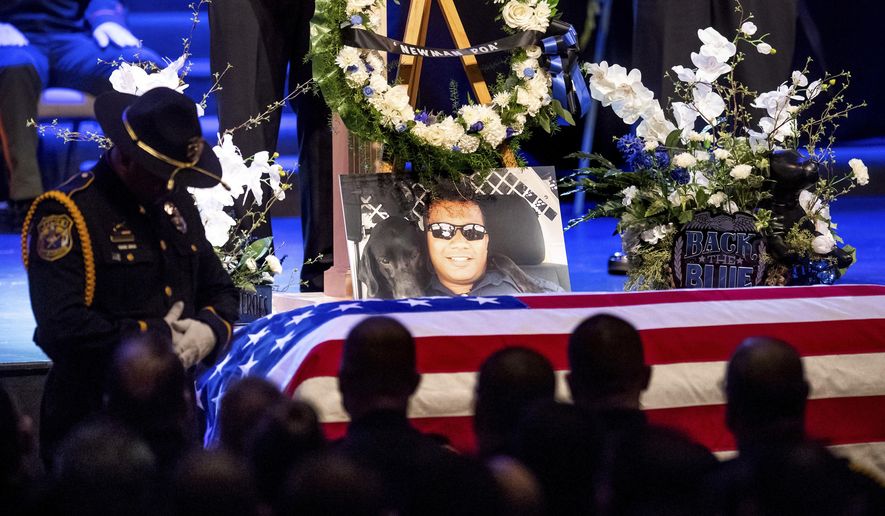 File - In this Jan. 5, 2019, file photo, a picture of slain Newman Police Cpl. Ronil "Ron" Singh rests atop the casket during his funeral in Modesto, Calif. Paulo Virgen Mendoza who has been charged in Singh's murder, has pleaded not guilty of the Dec. 26 slaying. Two men who are in the United States illegally have been convicted, Monday, Sept. 30, 2019, of aiding Mendoza as he tried to escape to Mexico. (AP Photo/Noah Berger, File)