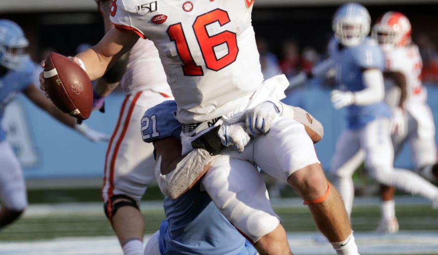 Clemson quarterback Trevor Lawrence (16) is pressured by North Carolina's Chazz Surratt (21) during the third quarter of an NCAA college football game in Chapel Hill, N.C., Saturday, Sept. 28, 2019. (AP Photo/Chris Seward)