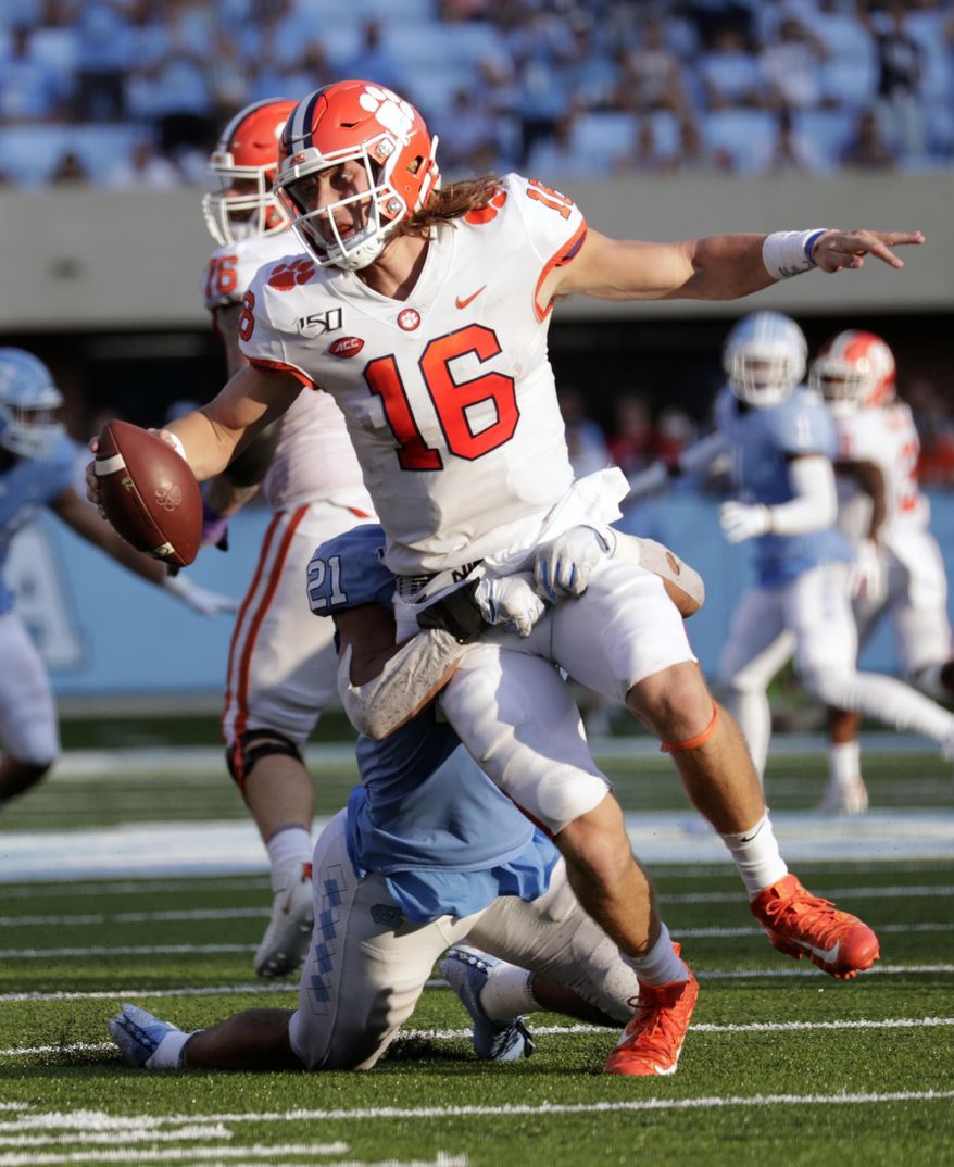 Clemson quarterback Trevor Lawrence (16) is pressured by North Carolina's Chazz Surratt (21) during the third quarter of an NCAA college football game in Chapel Hill, N.C., Saturday, Sept. 28, 2019. (AP Photo/Chris Seward)
