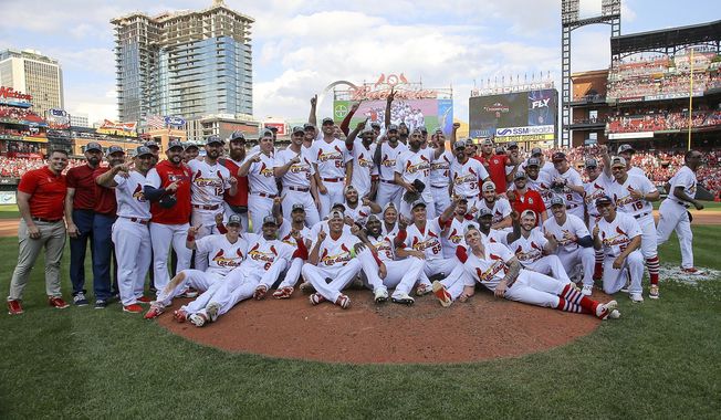 Members of the St. Louis Cardinals pose for a group picture as they celebrate their victory after a baseball game Sunday, Sept. 29, 2019, in St. Louis. The Cardinals clinched the NL Central on the final day of the regular season, to win their first division title since 2015 with a 9-0 victory over the Chicago Cubs. (AP Photo/Scott Kane)