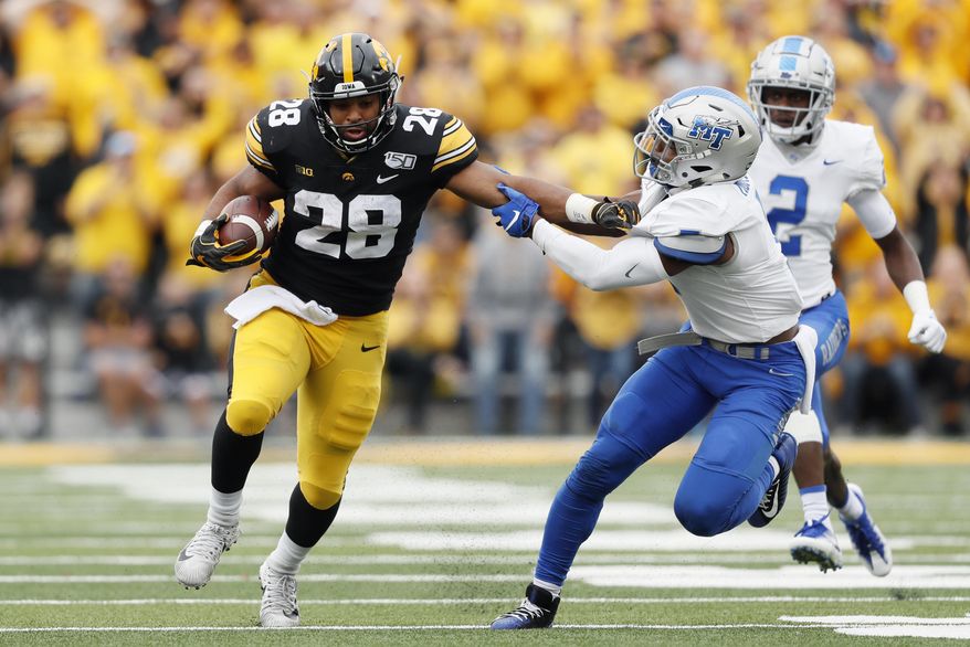 Iowa running back Toren Young (28) breaks a tackle by Middle Tennessee safety Jovante Moffatt, right, during the second half of an NCAA college football game, Saturday, Sept. 28, 2019, in Iowa City, Iowa. Iowa won 48-3. (AP Photo/Charlie Neibergall)
