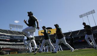 Oakland Athletics players warm up during baseball practice in Oakland, Calif., Tuesday, Oct. 1, 2019. The Athletics are scheduled to face the Tampa Bay Rays in an American League wild-card game Wednesday, Oct. 2. (AP Photo/Jeff Chiu)