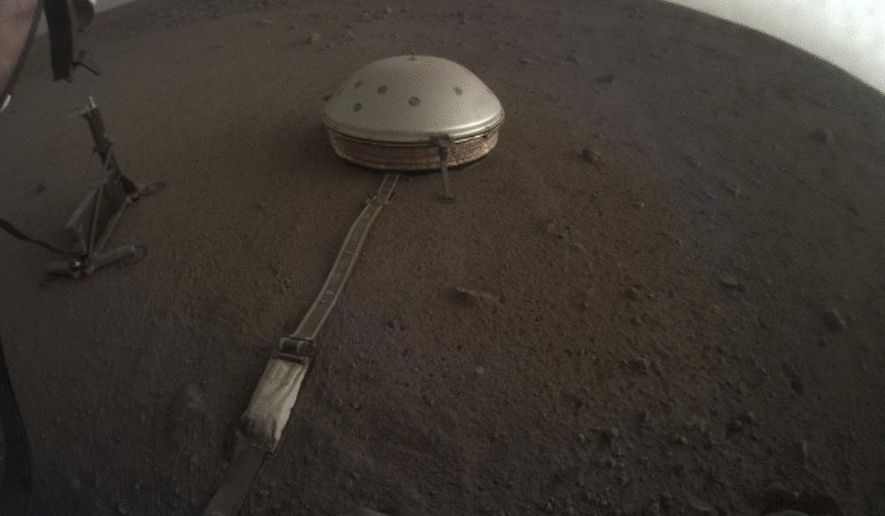 This April 25, 2019 photo made available by NASA shows the InSight lander's dome-covered seismometer, known as SEIS, on Mars. On Tuesday, Oct. 1, 2019, scientists released an audio sampling of marsquakes and other sounds recorded by the probe. (NASA/JPL-Caltech via AP)