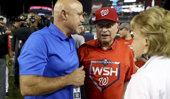 Washington Nationals General Manager Mike Rizzo, left, and Washington Nationals principal owner Mark Lerner, right, speak to each other on the field after the Washington Nationals defeat the Milwaukee Brewers 4-3 in a National League wild-card baseball game at Nationals Park, Tuesday, Oct. 1, 2019, in Washington. (AP Photo/Andrew Harnik)