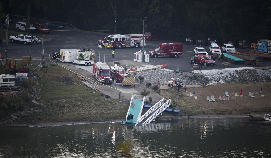 Emergency personnel respond after a barge struck the Ludlow Bromley Yacht Club in Ludlow, Ky., on Wednesday, Oct. 2, 2019. Kenton County Director of Homeland Security and Management Steve Hensley told news outlets the barge hit a marina near the yacht club Wednesday morning and knocked six boats loose in the Ohio River.(Albert Cesare/The Cincinnati Enquirer via AP)