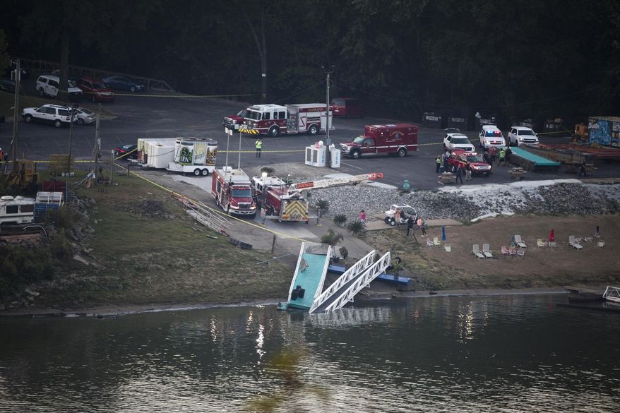 Emergency personnel respond after a barge struck the Ludlow Bromley Yacht Club in Ludlow, Ky., on Wednesday, Oct. 2, 2019. Kenton County Director of Homeland Security and Management Steve Hensley told news outlets the barge hit a marina near the yacht club Wednesday morning and knocked six boats loose in the Ohio River.(Albert Cesare/The Cincinnati Enquirer via AP)