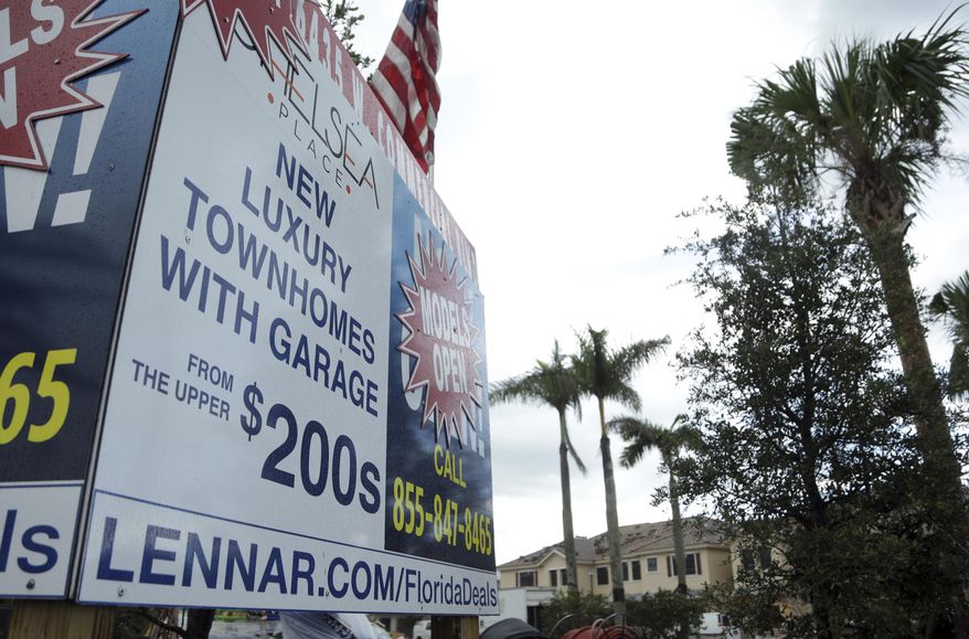 FILE - In this Sept. 22, 2016, file photo, a sign advertises Lennar Corporation townhomes which are under construction at Chelsea Place in Tamarac, Fla. Lennar Corporation reports financial results on Wednesday, Oct. 2, 2019. (AP Photo/Lynne Sladky, File)