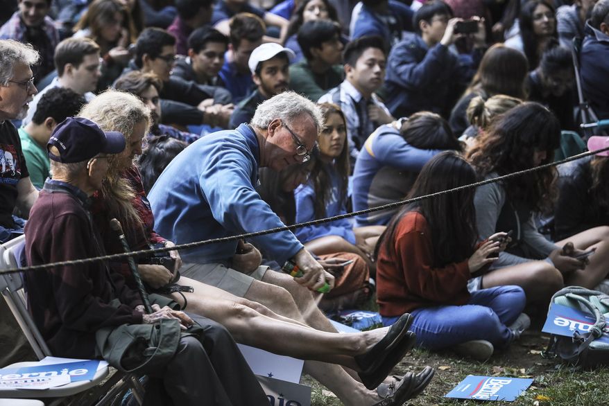 Attendees use bug spray fight off mosquitos while waiting for Democratic presidential candidate Sen. Bernie Sanders, I-Vt., to arrive at a campaign event Sunday, Sept. 29, 2019 at Dartmouth College in Hanover, N.H. (AP Photo/ Cheryl Senter)