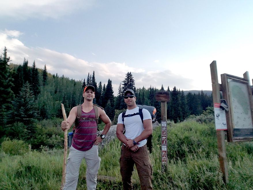 In this July 7, 2017 photo provided by Trevor Reilly shows Trevor Reilly, left, posing with Marine Pfc. Ali Al-kazahg while hiking in the Eagles Nest Wilderness of the Dillon Ranger District in Colorado. Al-kazahg faces a military hearing after the Hawaii-based Marine was apprehended at an Air Force base in Nebraska. Officials say he tried to bring weapons on to the base and made threats. (Trevor Reilly via AP)