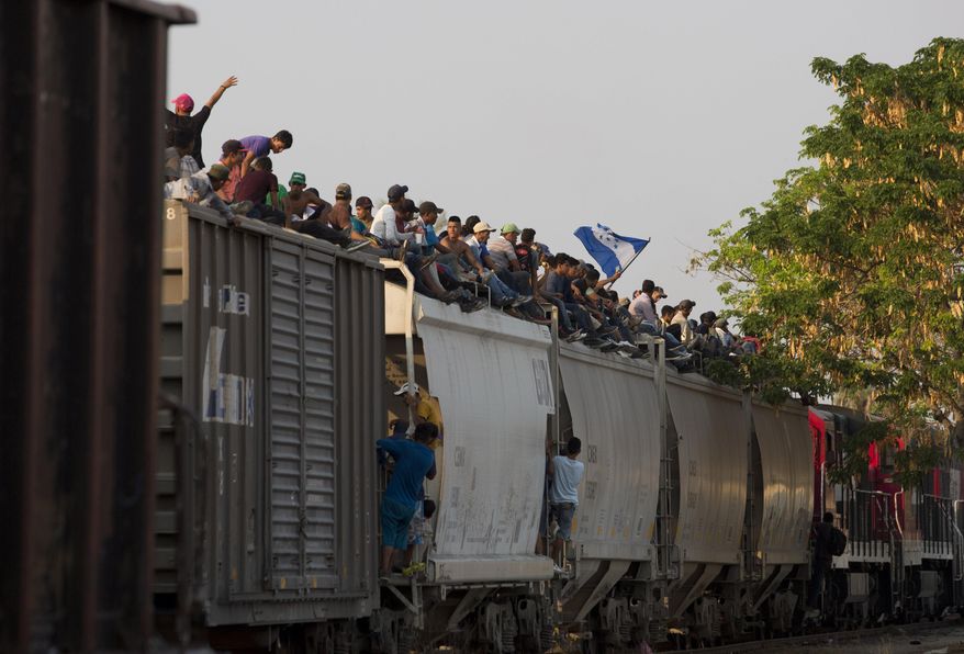 In this April 23, 2019, file photo, Central American migrants ride atop a freight train during their journey toward the U.S.-Mexico border, in Ixtepec, Oaxaca State, Mexico. (AP Photo/Moises Castillo, File)