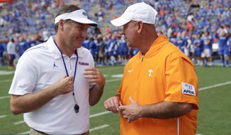 Florida head coach Dan Mullen, left, and Tennessee head coach Jeremy Pruitt greet each other on the field prior to an NCAA college football game, Saturday, Sept. 21, 2019, in Gainesville, Fla. (AP Photo/John Raoux)