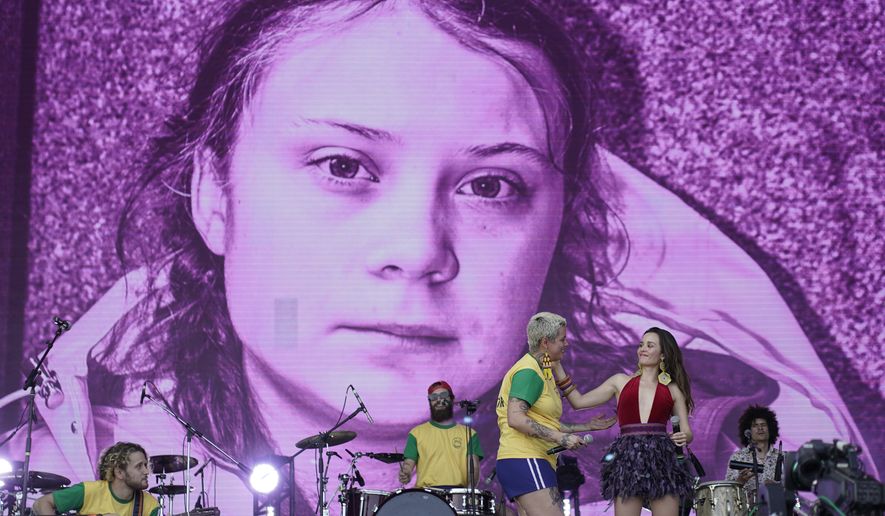 A picture of the Swedish activist and student Greta Thunberg is displayed on the big screen as Juliana Strassacapa of the Brazilian band Francisco, el Hombre and Catalina Garcia, of the Colombian band Monsieur Perine, right, perform at the Rock in Rio music festival in Rio de Janeiro, Brazil, Thursday, Oct. 3, 2019. (AP Photo/Leo Correa)