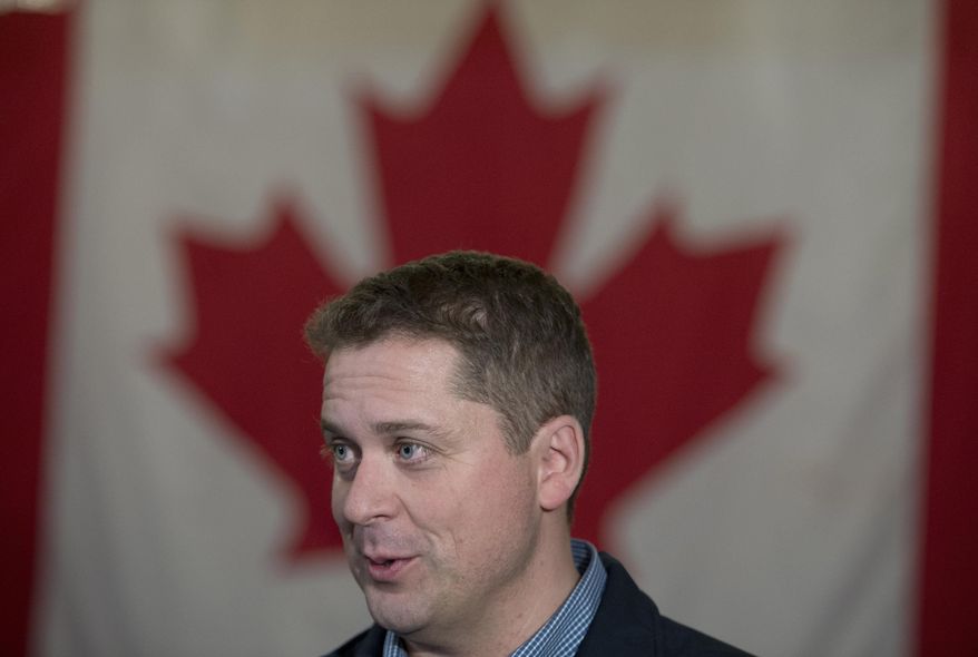 Conservative Leader Andrew Scheer speaks to the media following a campaign rally in Dartmouth, Nova Scotia, on Thursday, Oct. 3, 2019. A Canadian flag is in the background. (Jonathan Hayward/The Canadian Press via AP)