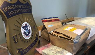 Evidence bags and money are displayed at a news conference, Wednesday, Oct. 2, 2019, in Portland, Ore. U.S. Attorney Billy Williams said that federal authorities in Oregon had completed one of the largest drug trafficking busts in state history that involved a vast international network of couriers, dealers and stash-house operators who smuggled methamphetamine, heroin and cocaine worth about $15 million from Mexico to Portland. (AP Photo/Gillian Flaccus) ** FILE **
